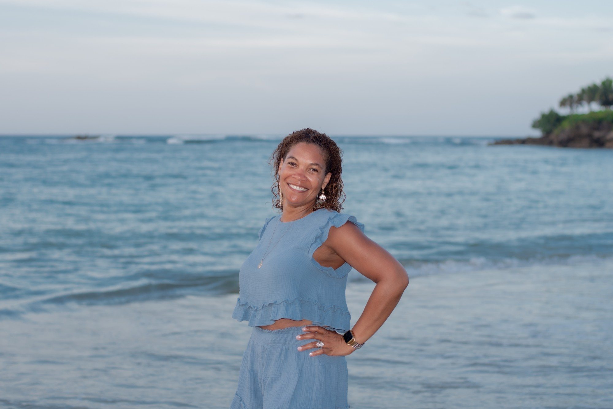 Lisa Brunson smiling on the beach, the ocean behind her